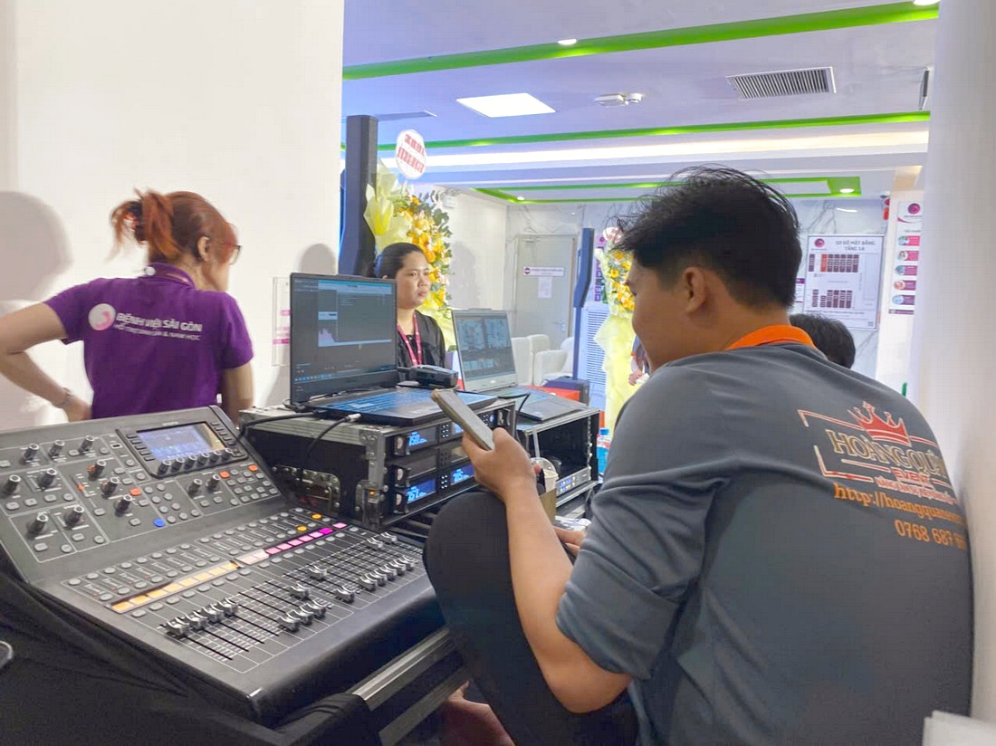 Kỹ thuật viên Hoàng Quân Event Solutions vận hành bàn điều khiển âm thanh cho tọa đàm y khoa