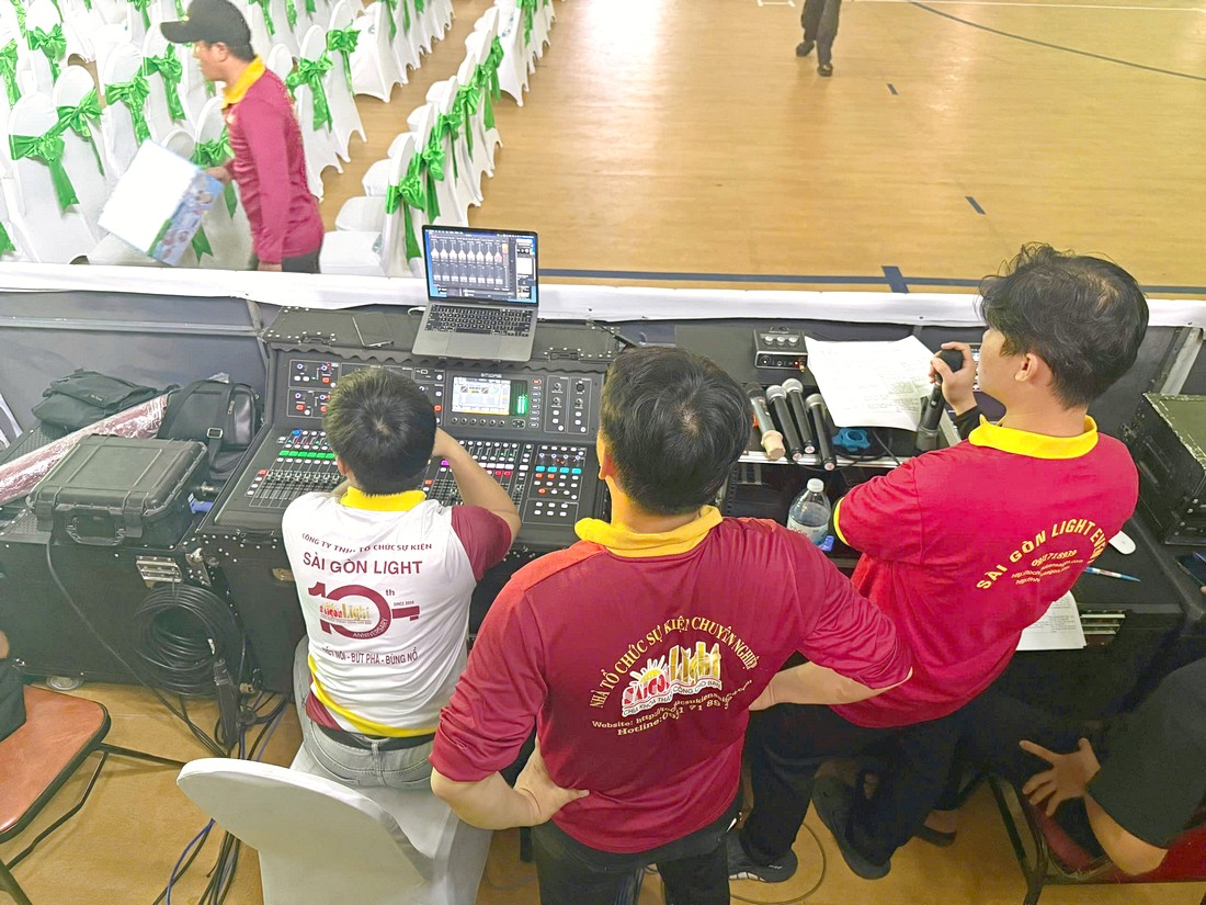 Kỹ thuật viên vận hành thiết bị tại khu vực FOH của sự kiện thể thao chuyên nghiệp.