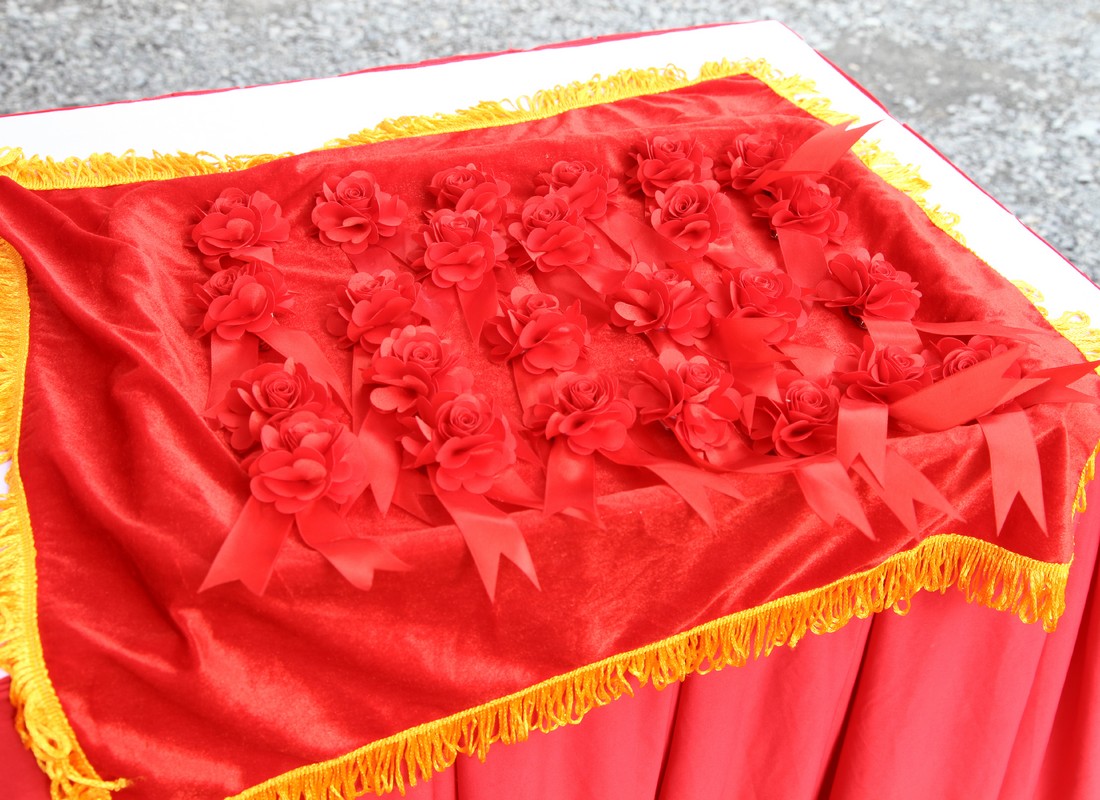 Hoa cài áo màu đỏ được chuẩn bị trên khay trước chương trình.