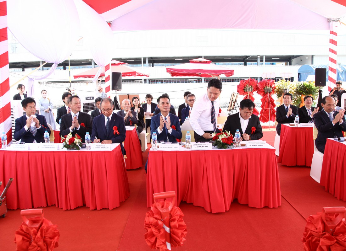 Một đại biểu đứng tại vị trí ngồi trong khi khách mời xung quanh vỗ tay.